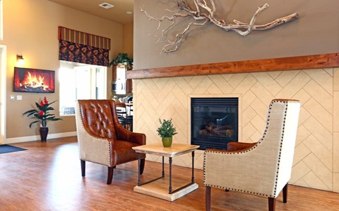 a living room with a fireplace and chairs